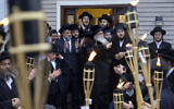 Community members celebrate the arrival of a new Torah at Chaim Rottenberg's residence, Sunday, December 29, 2019, in Monsey, New York. A day earlier, a knife-wielding man stormed into the home and stabbed multiple people as they celebrated Hanukkah in the Orthodox Jewish community. (AP Photo/Craig Ruttle)