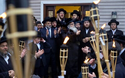 Community members celebrate the arrival of a new Torah at Chaim Rottenberg's residence, Sunday, December 29, 2019, in Monsey, New York. A day earlier, a knife-wielding man stormed into the home and stabbed multiple people as they celebrated Hanukkah in the Orthodox Jewish community. (AP Photo/Craig Ruttle)