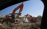 In this photo from January 1, 2019, men work on a new housing project in the West Bank settlement of Modin Illit. (AP Photo/Ariel Schalit)