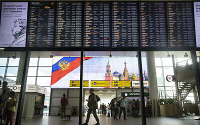 Illustrative: Passengers walk past a departure board at Sheremetyevo international airport in Moscow, Russia, July 8, 2019. (AP Photo/Pavel Golovkin)