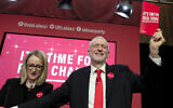 Jeremy Corbyn, former Leader of Britain's opposition Labour Party, holds a copy of the manifesto next to Rebecca Long-Bailey on stage at the launch of Labour's General Election manifesto, at Birmingham City University, England, Thursday, Nov. 21, 2019.  (AP Photo/Kirsty Wigglesworth)