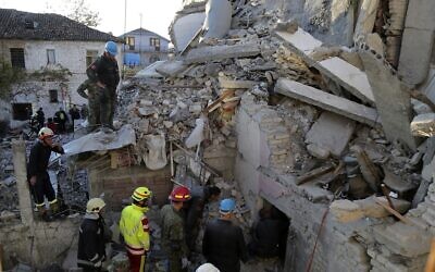 Rescuers try to free a man from a collapsed building, after a magnitude 6.4 earthquake in Thumane, western Albania, November 26, 2019. (AP Photo/Visar Kryeziu)