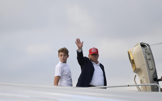 US President Donald Trump, standing with his son Barron, waves from the top of the steps of Air Force One at Palm Beach International Airport in West Palm Beach, Fla., Sunday, Dec. 1, 2019. (AP Photo/Susan Walsh) US President Donald Trump, standing with his son Barron, waves from the top of the steps of Air Force One at Palm Beach International Airport in West Palm Beach, Fla., Sunday, Dec. 1, 2019. (AP Photo/Susan Walsh)