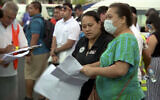 In this image from video, people gather outside a health emergency operation center Dec. 5, 2019, in Apia, Samoa (TVNZ via AP)