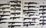 File: Semi-automatic rifles fill a wall at a gun shop in Lynnwood, Washington in October 2018 (AP Photo/Elaine Thompson, File)