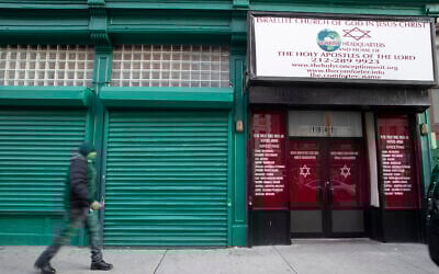 A pedestrian walks past the world headquarters of the Israelite Church of God in Jesus Christ, Thursday, Dec. 12, 2019, in the Harlem neighborhood of New York. (AP/Mary Altaffer)