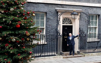 Britain's Prime Minister Boris Johnson waves as he arrives back at 10 Downing Street in London, Dec. 13, 2019 after meeting Queen Elizabeth II to seek her approval to form a new government (AP Photo/Thanassis Stavrakis)