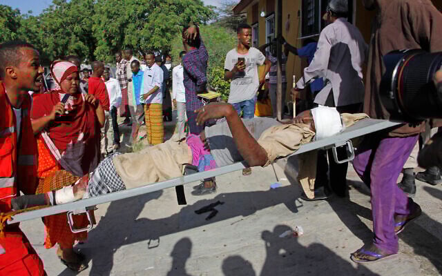 Medical personnel carry a civilian who was wounded in suicide car bomb attack at check point in Mogadishu, Somalia, December 28, 2019. (Farah Abdi Warsame/AP) Medical personnel carry a civilian who was wounded in suicide car bomb attack at check point in Mogadishu, Somalia, December 28, 2019. (Farah Abdi Warsame/AP)