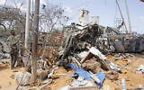 A soldier stands guard near wreckage of vehicles in Mogadishu after a car bomb in Mogadishu, Somalia, December 28, 2019. (AP Photo/Farah Abdi Warsame)