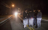 Orthodox Jewish men talk on Forshay Road in Monsey, NY, December 29, 2019, down the street from the scene of a stabbing rampage that occurred the night before, during a Hanukkah celebration. (AP/Allyse Pulliam)