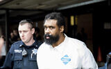 Ramapo police officers escort Grafton Thomas, the suspect in the Monsey attack, from Ramapo Town Hall to a police vehicle, in Ramapo, New York, December 29, 2019. (Julius Constantine Motal/AP)