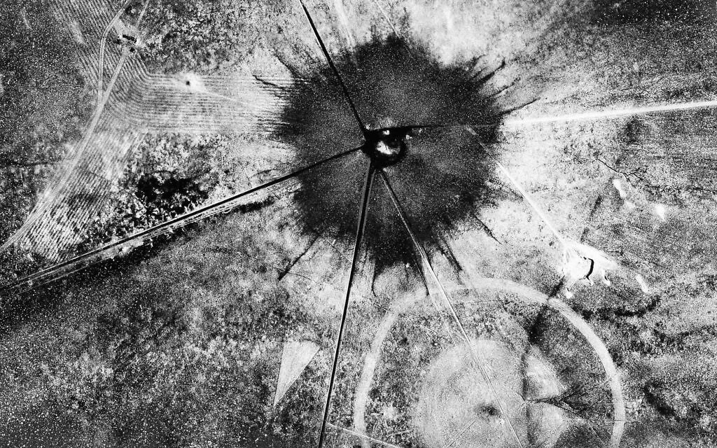 This is an aerial view of the aftermath of the first atomic explosion at Trinity Test Site, New Mexico, July 16, 1945.  It left a half-mile wide crater, 10 feet deep at the vent and the sand within the crater had been burned and boiled into a highly radioactive, jade-green, glassy crust. (AP Photo)