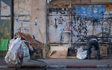 A man looks through garbage in the Florentin neighborhood of Tel Aviv. November 12, 2019 (Sara Klatt/FLASH90)