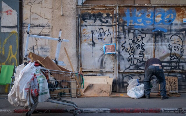 A man looks through garbage in the Florentin neighborhood of Tel Aviv. November 12, 2019 (Sara Klatt/FLASH90) A man looks through garbage in the Florentin neighborhood of Tel Aviv. November 12, 2019 (Sara Klatt/FLASH90)
