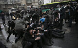 Ultra-Orthodox Jewish men block a road during a protest against the jailing of a Jewish seminary student who failed to comply with an army recruitment order, Jerusalem December 8, 2019. (Olivier Fitoussi/Flash90)