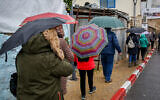 People walk in the rain in the northern Israeli city of Safed on December 9, 2019. (David Cohen/Flash90)