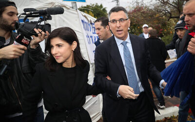Likud MK Gideon Saar arrives with his wife Geula Even-Sa'ar, a former TV news anchor, at a voting station to cast his vote in the Likud leadership race, in Tel Aviv, on December 26, 2019. (Yonatan Sindel/Flash90)