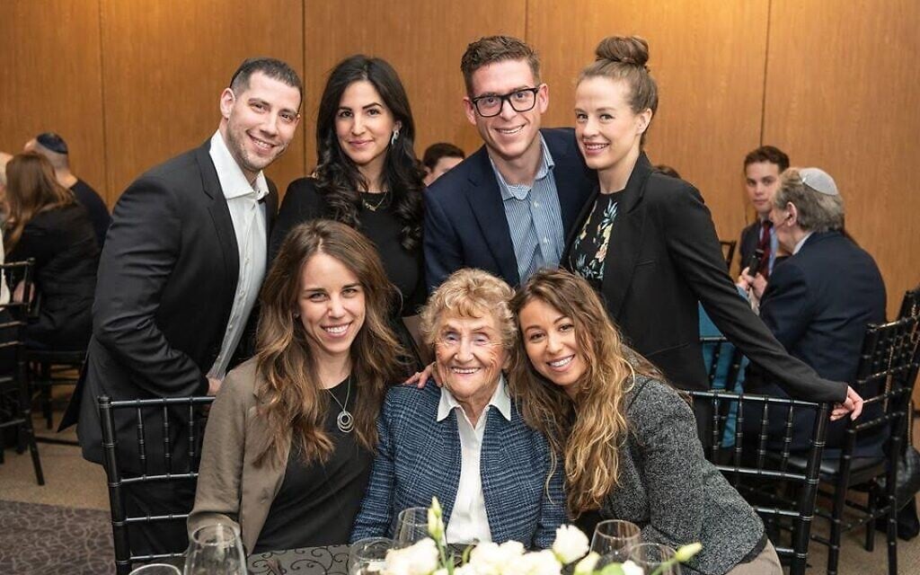 Holocaust survivor Rose Lipszyc, front center, and her granddaughter Brittney Hofbauer, front right, pose with table mates at the Dinner of Miracles in Toronto, December 15, 2019. (Liora Kogan)