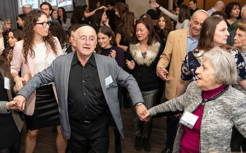 Holocaust survivors join with attendees to dance the hora at the Dinner of Miracles in Toronto, December 15, 2019. (Liora Kogan)