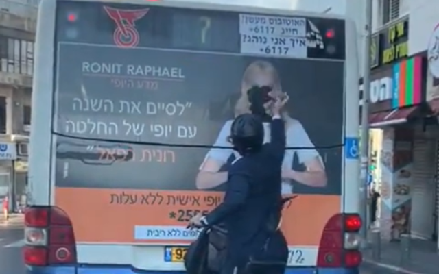 An ultra-Orthodox man vandalizing a campaign ad on a bus by tearing off the face of a woman from a poster, in footage published on December 8, 2019. (Screenshot: Twitter) An ultra-Orthodox man vandalizing a campaign ad on a bus by tearing off the face of a woman from a poster, in footage published on December 8, 2019. (Screenshot: Twitter)