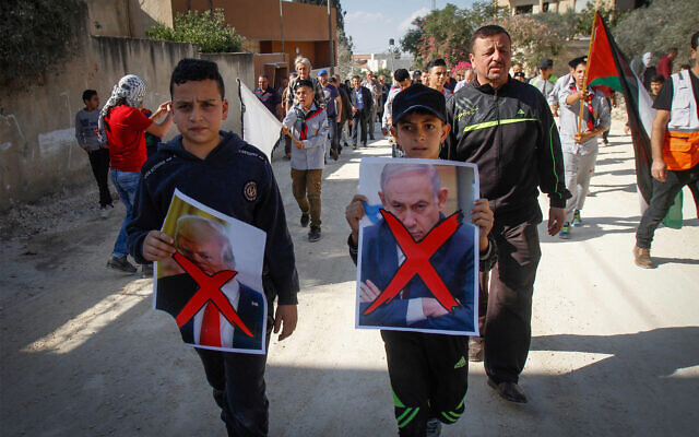 Palestinian demonstrators hold pictures of US President Donald Trump and and Prime Minister Benjamin Netanyahu during a protest in the village of Kfar Qaddum, near the West Bank city of Nablus, November 29, 2019. (Nasser Ishtayeh/Flash90) Palestinian demonstrators hold pictures of US President Donald Trump and and Prime Minister Benjamin Netanyahu during a protest in the village of Kfar Qaddum, near the West Bank city of Nablus, November 29, 2019. (Nasser Ishtayeh/Flash90)