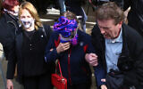 A 19-year old British woman, center, covers her face as she leaves the Famagusta court after her trial, in Paralimni, Cyprus, December 30, 2019. (AP Photo/Philippos Christou)