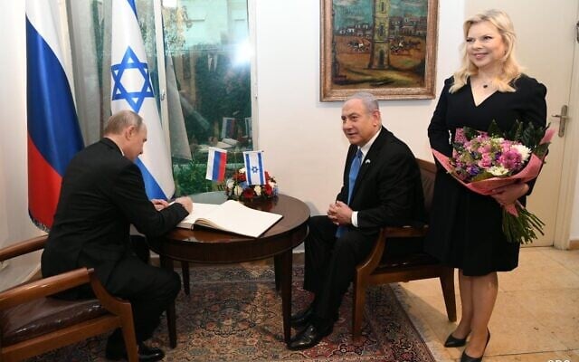 Russian President Vladimir Putin (L) signs the guest book at the Prime Minister's Residence, with Prime Minister Benjamin Netanyahu (C) and his wife, Sara (R), Jerusalem, 23 January, 2020 (Amos Ben Gershon/GPO) Russian President Vladimir Putin (L) signs the guest book at the Prime Minister's Residence, with Prime Minister Benjamin Netanyahu (C) and his wife, Sara (R), Jerusalem, 23 January, 2020 (Amos Ben Gershon/GPO)