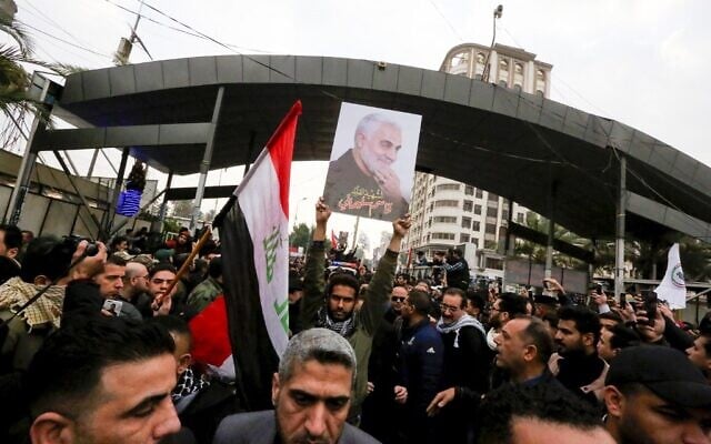 Mourners wave the national flag and the Hashed al-Shaabi flag as they carry the portrait Iranian military commander Qasem Soleimani during a funeral procession in Kadhimiya, a Shiite pilgrimage district of Baghdad, on January 4, 2020. (SABAH ARAR / AFP) Mourners wave the national flag and the Hashed al-Shaabi flag as they carry the portrait Iranian military commander Qasem Soleimani during a funeral procession in Kadhimiya, a Shiite pilgrimage district of Baghdad, on January 4, 2020. (SABAH ARAR / AFP)