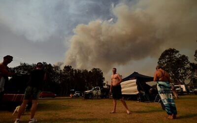 People take shelter by the beach as a bushfire burns in Batemans Bay in New South Wales on January 4, 2020 (PETER PARKS / AFP)