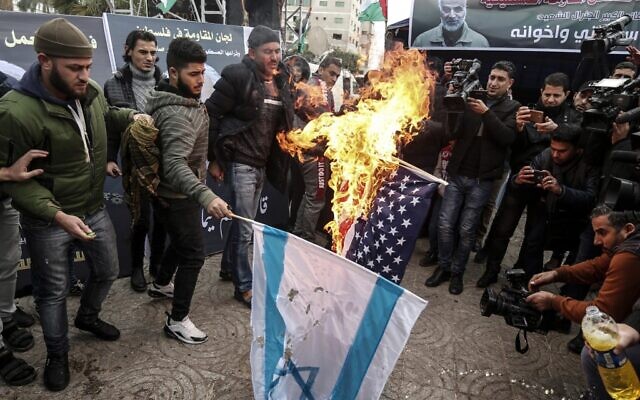 Palestinians in Gaza City burn a US and an Israeli flag during a mourning ceremony organized in honor of slain Iranian military commander Qassem Soleimani (portrait on banner) killed in a US airstrike a day earlier, on January 4, 2020. (Mahmud Hams/AFP) Palestinians in Gaza City burn a US and an Israeli flag during a mourning ceremony organized in honor of slain Iranian military commander Qassem Soleimani (portrait on banner) killed in a US airstrike a day earlier, on January 4, 2020. (Mahmud Hams/AFP)
