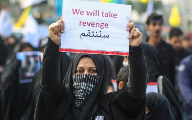 An Iraqi woman holds a placard during the funeral of Iranian military commander Qasem Soleimani, Iraqi paramilitary chief Abu Mahdi al-Muhandis and eight others in Baghdad's district of al-Jadriya on January 4, 2020. (AHMAD AL-RUBAYE / AFP) An Iraqi woman holds a placard during the funeral of Iranian military commander Qasem Soleimani, Iraqi paramilitary chief Abu Mahdi al-Muhandis and eight others in Baghdad's district of al-Jadriya on January 4, 2020. (AHMAD AL-RUBAYE / AFP)