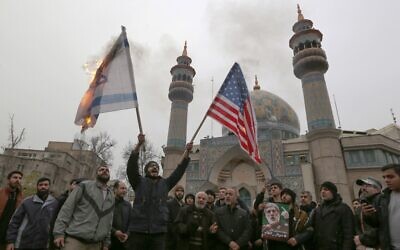 Iranians burn an Israeli and a US flag during an anti-US protest in the capital Tehran on January 4, 2020, over the killings during a US airstrike of Iranian military commander Qasem Soleimani and Iraqi paramilitary chief Abu Mahdi al-Muhandis. (Atta Kenare/AFP)