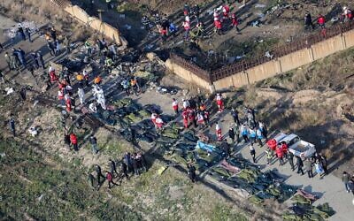 People and rescue teams amid bodies and debris after a Ukrainian plane carrying 176 passengers crashed near Imam Khomeini airport in the Iranian capital Tehran, killing everyone on board, January 8, 2020. (Rouhollah Vahdati/ISNA/AFP)
