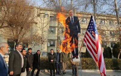 Members of the Basij, a militia loyal to the Islamic republic's establishment, burn a cardboard cutout of Britain's ambassador Rob Macaire alongside a Union Jack and US flag during a memorial for victims of the Ukraine plane crash, at University of Tehran on January 14, 2020. (ATTA KENARE / AFP)