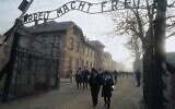 Holocaust survivors walk below the gate with its inscription 'Work sets you free' after a wreath laying at the death wall at the memorial site of the former Nazi death camp Auschwitz during ceremonies to commemorate the 75th anniversary of the camp's liberation in Oswiecim, Poland, on January 27, 2020. (Janek Skarzynski/ AFP/ File)