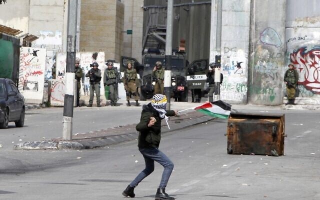 A Palestinian rioter hurls a rock during clashes with Israeli security forces following a protest in the West Bank city of Bethlehem on January 29, 2020. (Musa AL SHAER / AFP) A Palestinian rioter hurls a rock during clashes with Israeli security forces following a protest in the West Bank city of Bethlehem on January 29, 2020. (Musa AL SHAER / AFP)