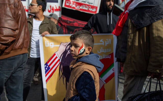 A child with the colors of the Iraqi flag on his face walks past a poster with Arabic that reads "leave us live in peace," during the ongoing protests in Tahrir square, Baghdad, Iraq, Friday, Jan. 10, 2020. (AP Photo/Nasser Nasser) A child with the colors of the Iraqi flag on his face walks past a poster with Arabic that reads "leave us live in peace," during the ongoing protests in Tahrir square, Baghdad, Iraq, Friday, Jan. 10, 2020. (AP Photo/Nasser Nasser)