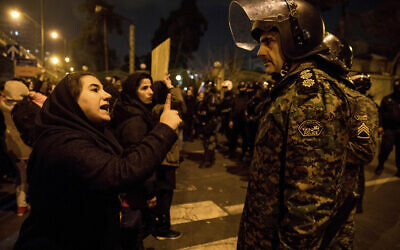 Illustrative: In this January 11, 2020 photo, released by Iranian Students' News Agency, ISNA, a woman attending a candlelight vigil to remember the victims of the Ukraine plane crash, talks to a policeman, at the gate of Amri Kabir University in Tehran, Iran. (Mona Hoobehfekr/ISNA via AP)