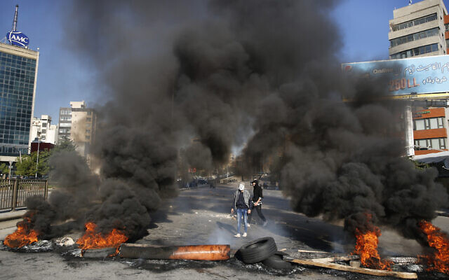 Anti-government protesters burn tires during ongoing protests after weeks of calm in Beirut, Lebanon, January 14, 2020. (Hussein Malla/AP) Anti-government protesters burn tires during ongoing protests after weeks of calm in Beirut, Lebanon, January 14, 2020. (Hussein Malla/AP)