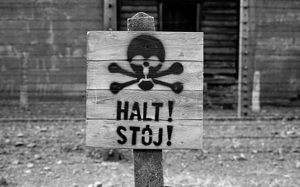 A wooden sign with the word STOP stands in front of what was an electric barbed wire fence inside the former Nazi death camp of Auschwitz I, in Oswiecim, Poland, December 8, 2019. (Markus Schreiber/AP)