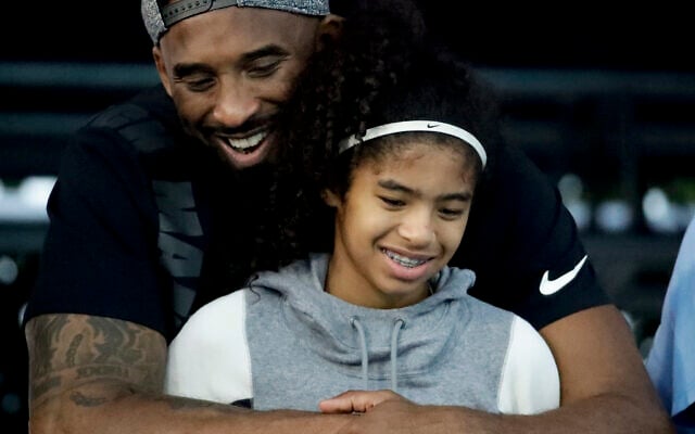 In this July 26, 2018 file photo former Los Angeles Laker Kobe Bryant and his daughter Gianna watch during the US national championships swimming meet in Irvine, Calif. Bryant, the 18-time NBA All-Star who won five championships and became one of the greatest basketball players of his generation during a 20-year career with the Los Angeles Lakers, died in a helicopter crash Sunday, Jan. 26, 2020. Gianna also died in the crash. She was 13. (AP Photo/Chris Carlson) In this July 26, 2018 file photo former Los Angeles Laker Kobe Bryant and his daughter Gianna watch during the US national championships swimming meet in Irvine, Calif. Bryant, the 18-time NBA All-Star who won five championships and became one of the greatest basketball players of his generation during a 20-year career with the Los Angeles Lakers, died in a helicopter crash Sunday, Jan. 26, 2020. Gianna also died in the crash. She was 13. (AP Photo/Chris Carlson)