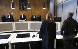 Dutch-Palestinian man Ismail Zeyada, originally from the Gaza Strip, right, and his lawyer Liesbeth Zegveld, rise as judges enter The Hague District Court, Netherlands, January 29, 2020. (Peter Dejong/AP)