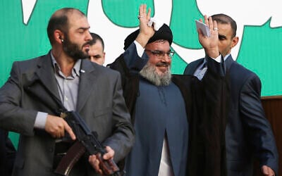 Hezbollah leader Sheik Hassan Nasrallah, center, escorted by his bodyguards, waves to a crowd of tens of thousands of supporters during a rally in a southern suburb of Beirut, Lebanon, September 17, 2012. AP Photo/Hussein Malla, File)