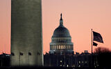 The US Capitol building, center, is seen next to the bottom part of the Washington Monument, left, before sunrise on Capitol Hill in Washington, December 19, 2019 (AP Photo/Julio Cortez)