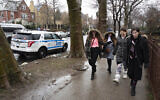 Jewish girls walk by a police car stationed in the Crown Heights neighborhood, Monday, Dec. 30, 2019 in the Brooklyn borough of New York. Police have increased patrols in the area following anti-Semitic attacks in the city and on an attack of a Hanukkah celebration in Monsey, N.Y. (AP Photo/Mark Lennihan)