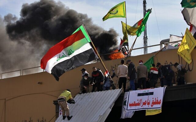 Pro-Iranian militiamen and their supporters set a fire during a sit-in in front of the US embassy in Baghdad, Iraq, January 1, 2020. (AP Photo/Khalid Mohammed) Pro-Iranian militiamen and their supporters set a fire during a sit-in in front of the US embassy in Baghdad, Iraq, January 1, 2020. (AP Photo/Khalid Mohammed)