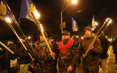 Activists of various nationalist parties carry torches during a rally in Kyiv, Ukraine on January 1, 2020. (AP Photo/Efrem Lukatsky)
