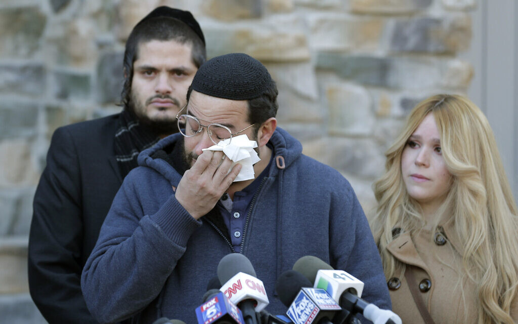 Surrounded by family, David Neumann, center, wipes his eyes as he speaks to reporters in New City, New York, Thursday, Jan. 2, 2020, about his father, Josef Neumann, who was critically injured in an attack on a Hanukkah celebration (AP Photo/Seth Wenig) Surrounded by family, David Neumann, center, wipes his eyes as he speaks to reporters in New City, New York, Thursday, Jan. 2, 2020, about his father, Josef Neumann, who was critically injured in an attack on a Hanukkah celebration (AP Photo/Seth Wenig)