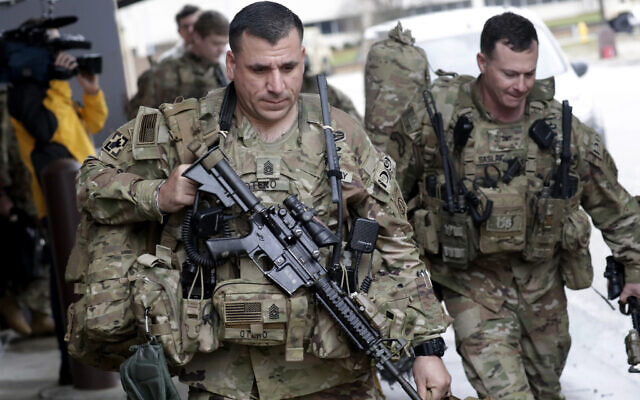 US Army soldiers with their gear head to an awaiting bus on January 4, 2020 at Fort Bragg, NC, as troops from the 82nd Airborne are deployed to the Middle East as reinforcements in the volatile aftermath of the killing of Iranian Gen. Qassem Soleimani. (AP Photo/Chris Seward) US Army soldiers with their gear head to an awaiting bus on January 4, 2020 at Fort Bragg, NC, as troops from the 82nd Airborne are deployed to the Middle East as reinforcements in the volatile aftermath of the killing of Iranian Gen. Qassem Soleimani. (AP Photo/Chris Seward)