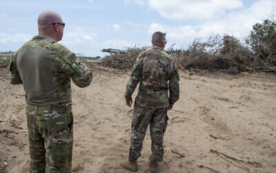 In this photo taken February 24, 2018 and released by the US Air Force, US servicemen look at trees that are being cleared during a battlefield circulation site visit at Camp Simba, Manda Bay, Kenya. (Staff Sgt. Timothy Moore/U.S. Air Force via AP)